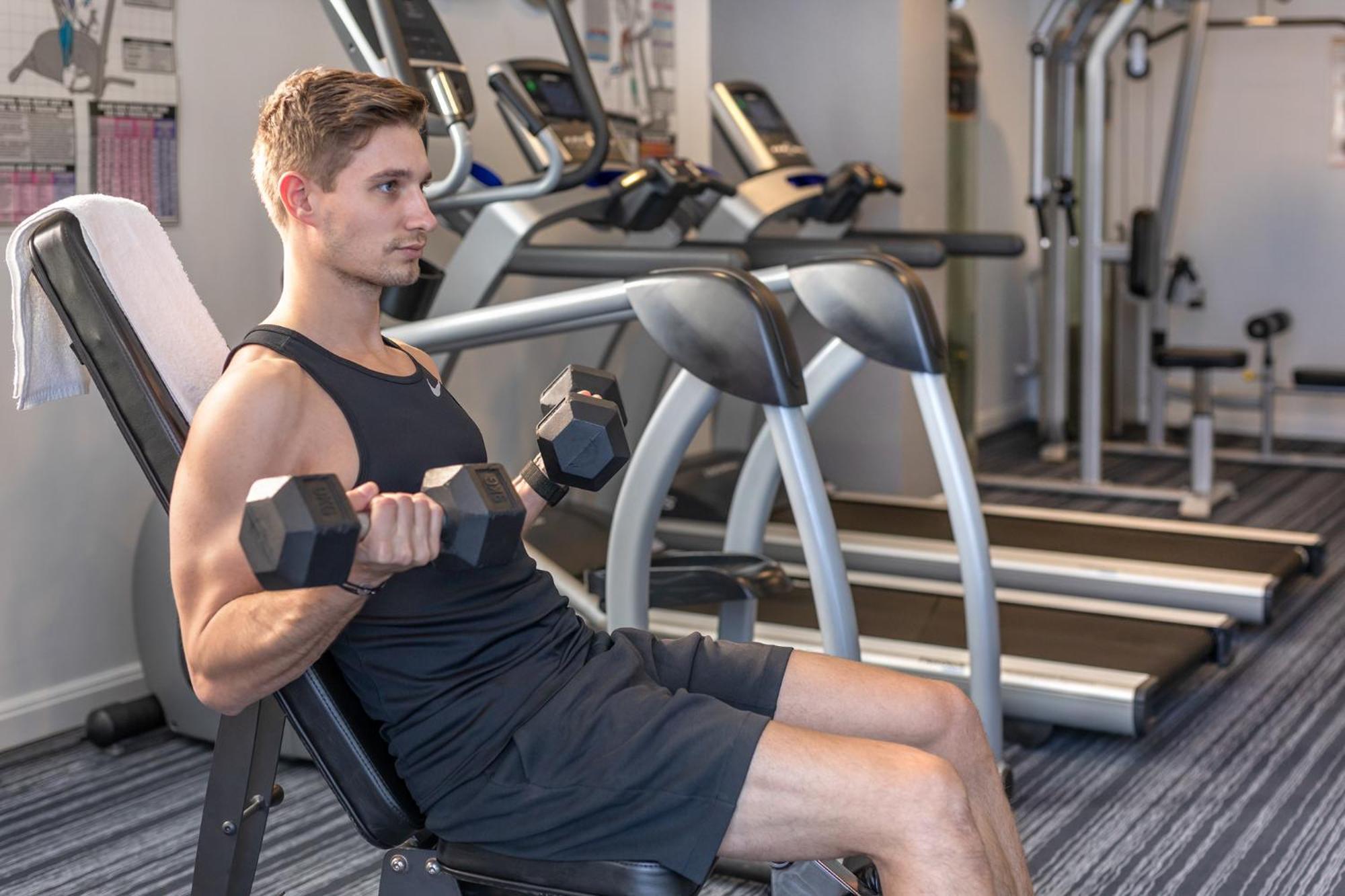 Meriton Suites North Ryde Sídney Exterior foto A man using a dumbbell to exercise
